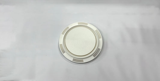 Round silver plate with decorative rim on a gray background